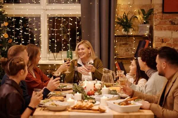 family having dinner surrounded by Christmas decorations